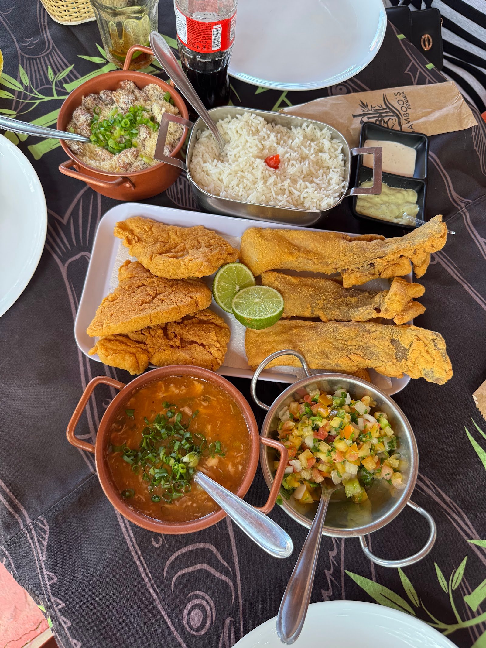 Prato completo de peixe cuiabano com arroz, pirão cremoso, farofa e molho de pimenta em panelas de barro e inox